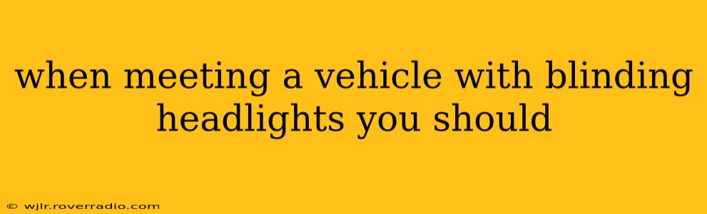 when meeting a vehicle with blinding headlights you should